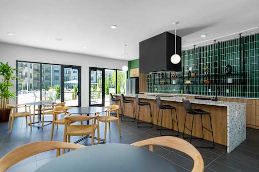 A modern kitchen with a bar area and a dining table.