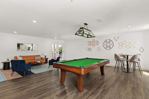 A room with a pool table and a hanging light fixture.