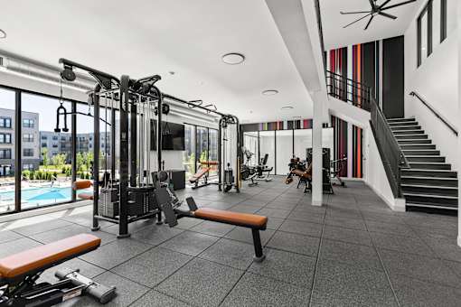 A gym with a view of a pool and buildings outside.