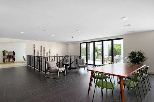 A modern dining room with a long table and chairs.