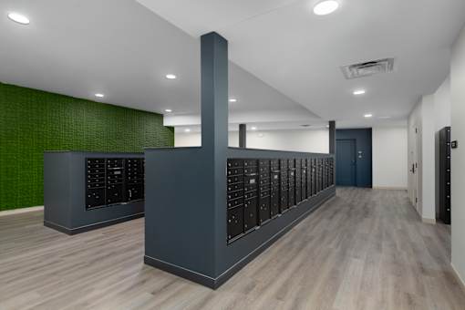 A long hallway with a row of server racks on the wall.