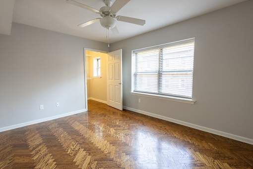 a bedroom with hardwood floors and a ceiling fan
