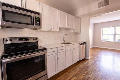 a kitchen with white cabinets and stainless steel appliances