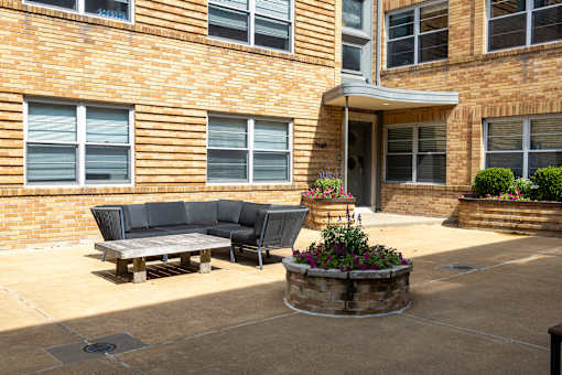 a patio with a couch and a table in front of a building