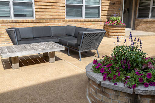 a patio with a wooden bench and a wooden table