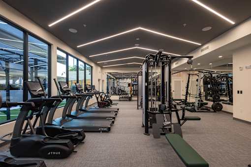 a gym with cardio equipment and weights on the floor of a building
