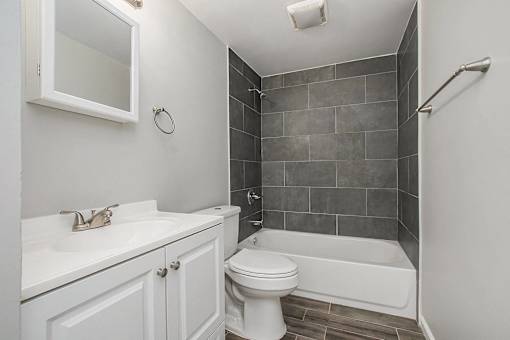 A white toilet sits next to a sink in a bathroom.