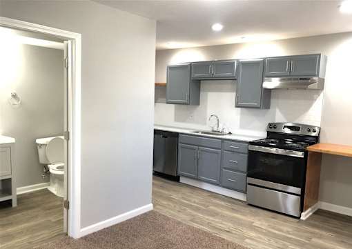 A kitchen with a stove, oven, and cabinets.