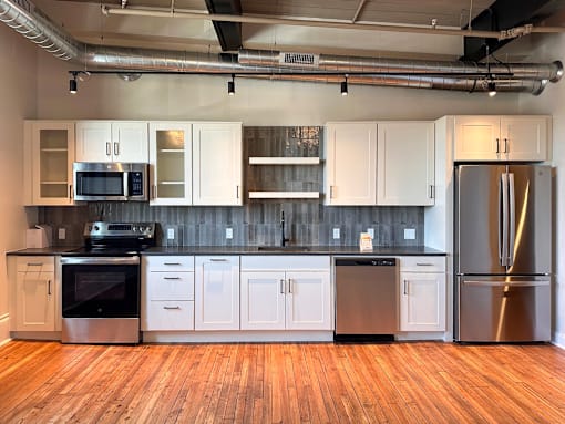 A kitchen with white cabinets and stainless steel appliances.