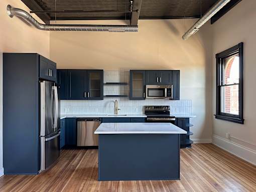 A kitchen with dark blue cabinets and a white countertop.