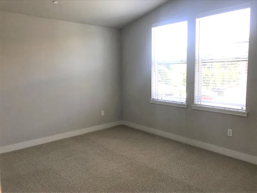 an empty room with three windows in it