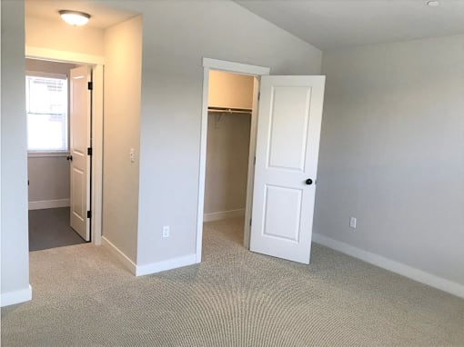 an empty bedroom with a closet and an open door