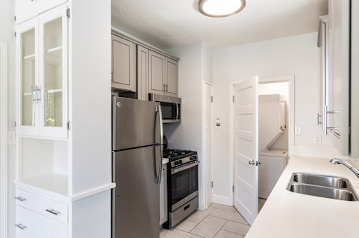 a renovated kitchen with stainless steel appliances and white cabinets