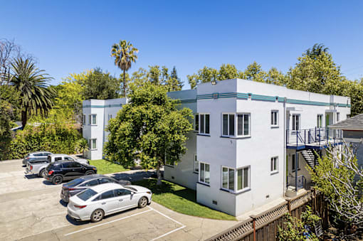 a white apartment building with cars parked in front of it