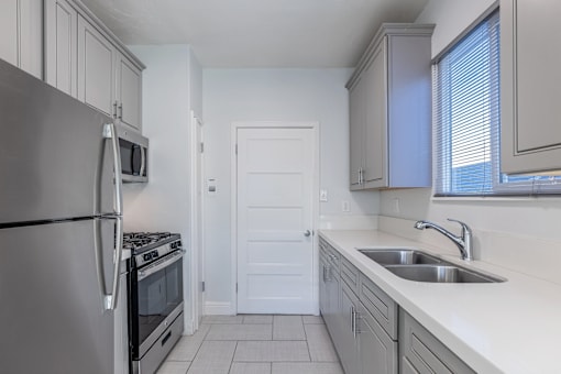 an empty kitchen with a sink and a refrigerator