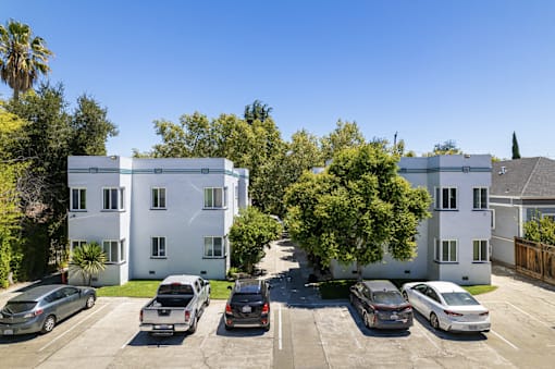 an aerial view of an apartment complex with cars parked in a parking lot