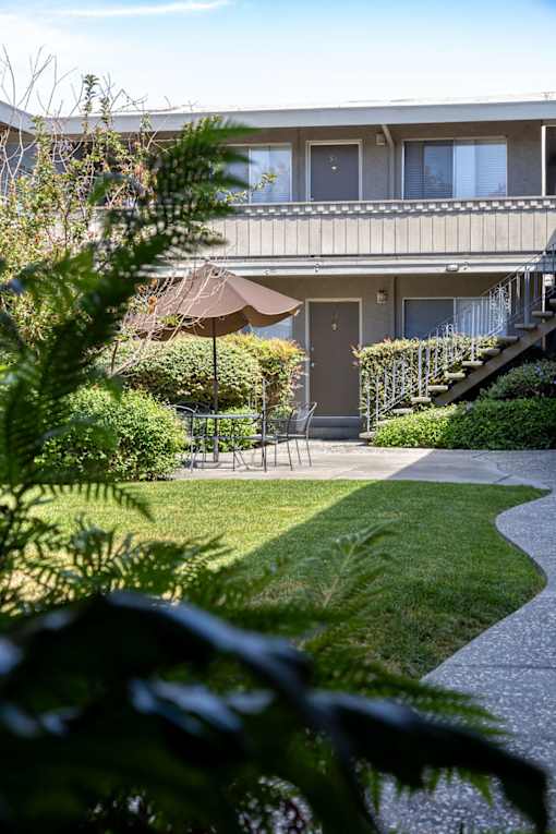 a patio with an umbrella in front of a house