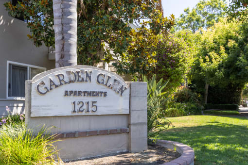 a sign for garden city apartments in front of a tree