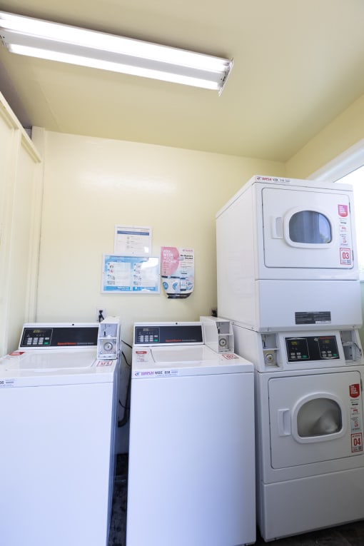 two washers and two washing machines in a laundry room