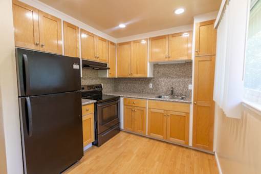 a kitchen with black appliances and wooden cabinets