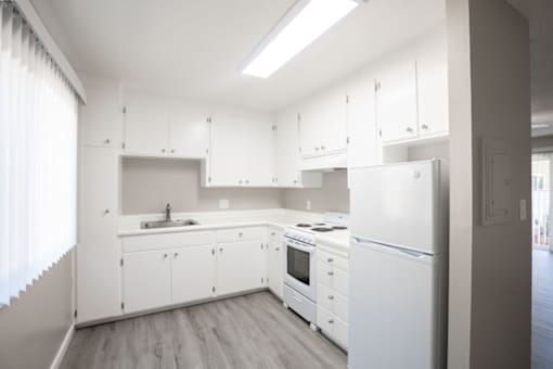 a white kitchen with white cabinets and white appliances