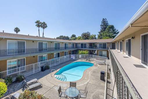 a pool is shown in the courtyard of a hotel