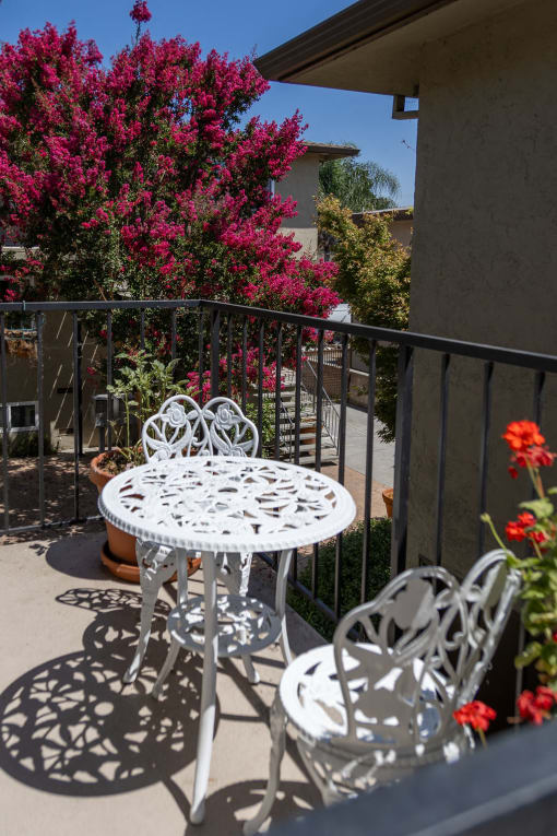 a patio with a white table and chairs on a balcony