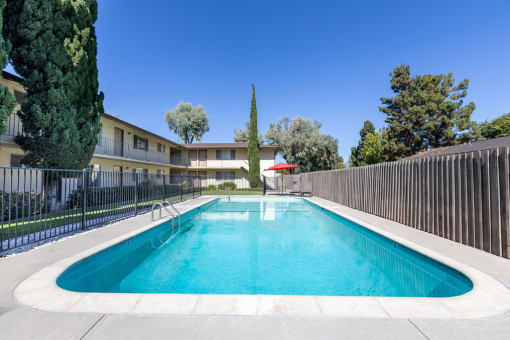 a swimming pool with an apartment building in the background