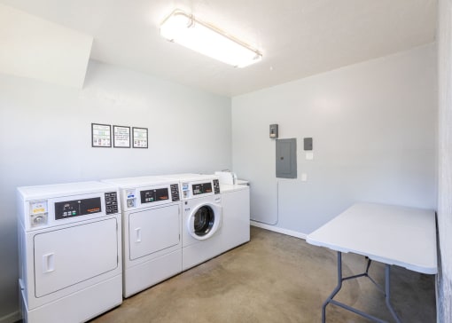 a laundry room with washing machines and a table