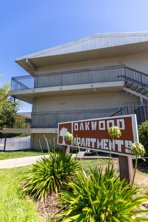 an apartment building with a sign in front of it