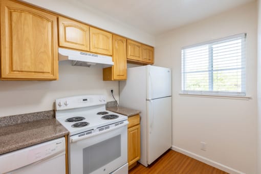 a kitchen with white appliances and wooden cabinets