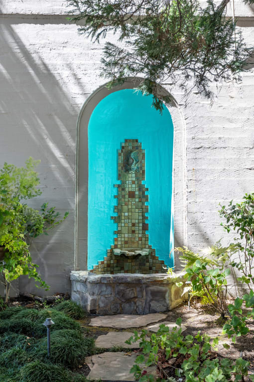 a sculpture of a building in an archway in a garden