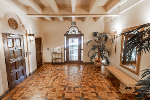 the entrance hall of a house with a wooden door and a wooden bench