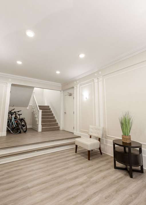 a living room with a staircase and a table and a chair