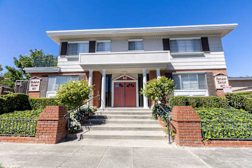 the front of a house with stairs and a red door