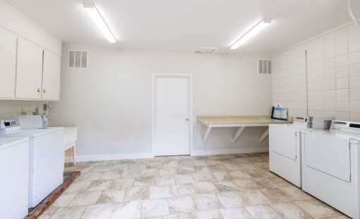 a laundry room with white appliances and a counter
