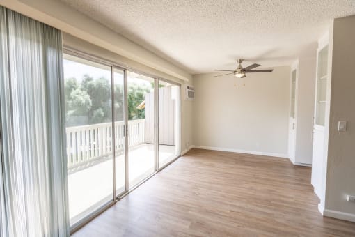 an empty living room with sliding glass doors to a balcony