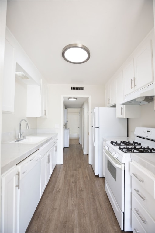 a white kitchen with white appliances and white cabinets