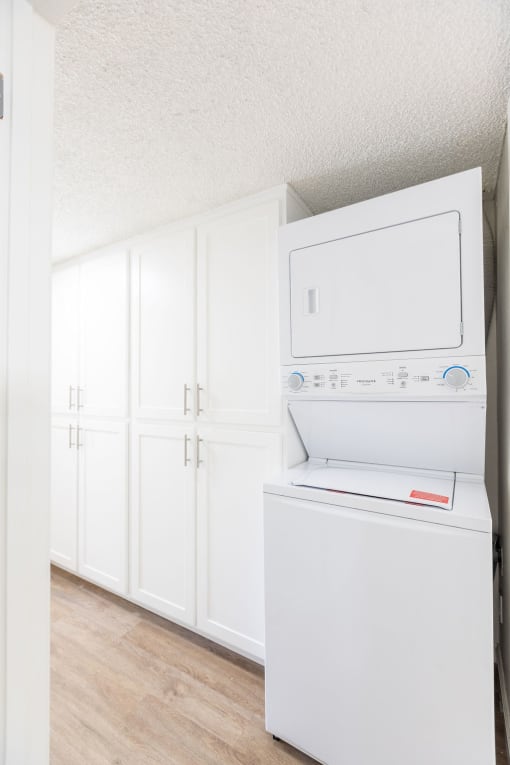 a white kitchen with a refrigerator and a microwave