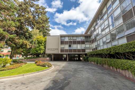 The image shows a building with the name "Royal Fines" on it, surrounded by greenery and a paved area in front.