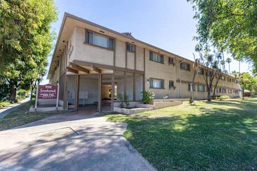 the front of a building with a sidewalk and grass