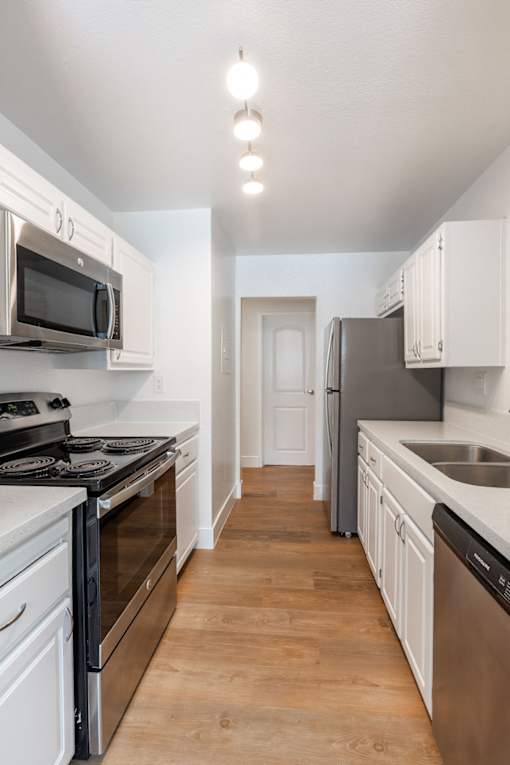 a kitchen with stainless steel appliances and white cabinets