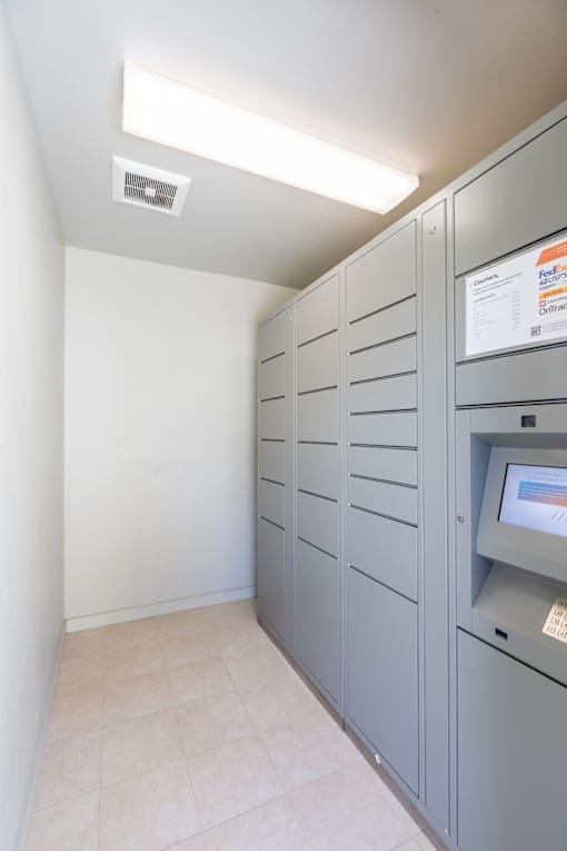 a utility room with gray cabinets and a white wall with a microwave