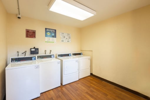 a laundry room with four washes and dryers in it