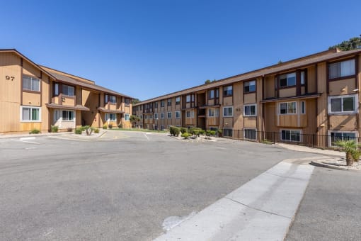 an empty parking lot in front of an apartment building