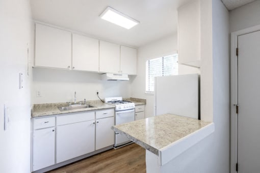 a kitchen with white cabinets and a counter top