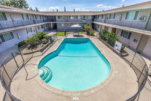 a resort style pool is in the middle of an apartment building