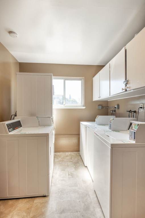 a white kitchen with white cabinets and a window