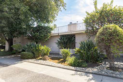 a house with a garden and trees in front of it