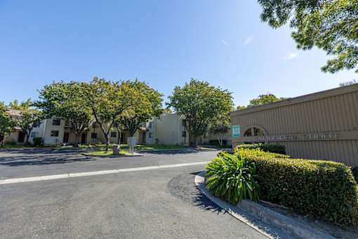 a parking lot in front of a building with trees